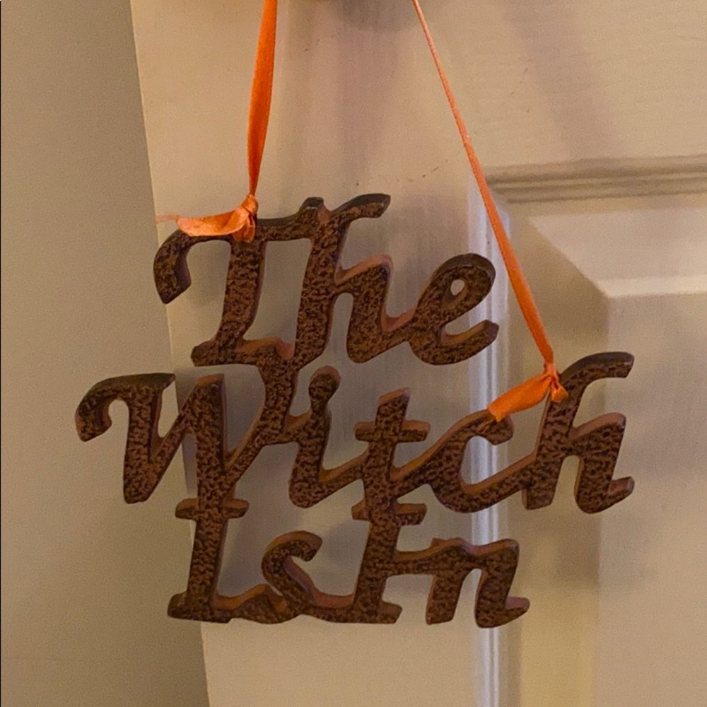 “The Witch Is In” metal sign